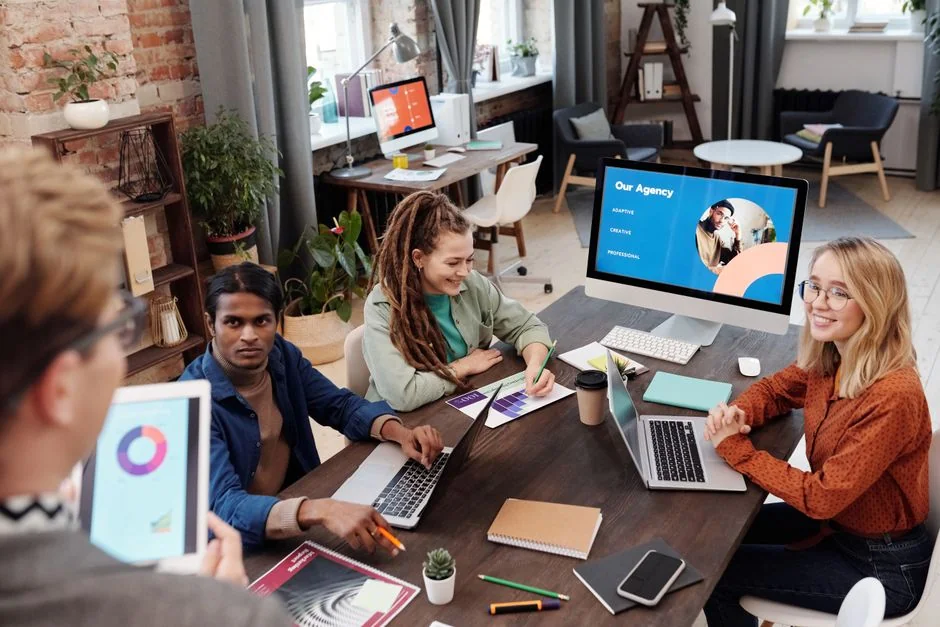 A diverse team of young professionals engaged in a business meeting analyzing graphs and data.